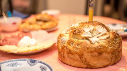 Slavski kolač sa svećom na postavljenom stolu