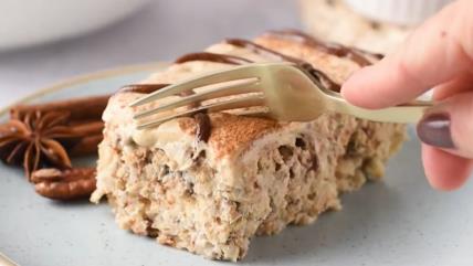 Zapečena ovsena kaša sa ukusom cimet rolnica na tanjiru presečena viljuškom