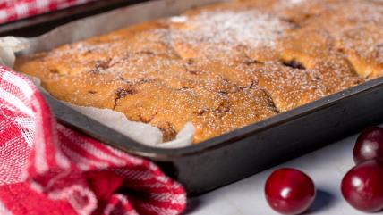 Kolač sa višnjama u tepsiji, posut sa šećerom u prahu