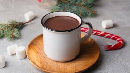 Topla čokolada u šolji na astolu okružena božićnom dekoracijom