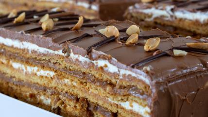 Parče snikers torte sa čokoladnom glazurom i kikirikijem