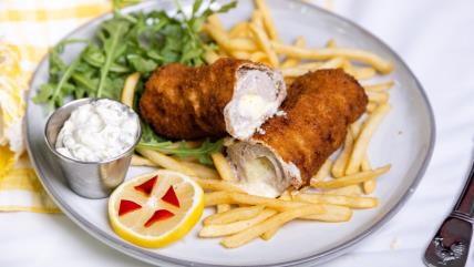 Karađorđeva šnicla sa dimljenim sirom na tanjiru sa pomfritom, rukolom, limunom i tartar sosom