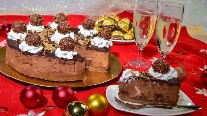 Ferero roše čizkejk na tanjiru na stolu koji je ukrašen za Novu godinu