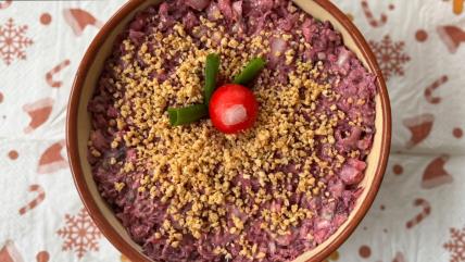 Posna slata od ljubičastog kupusa i kikirikija u činiji ukrašena rotkvicom