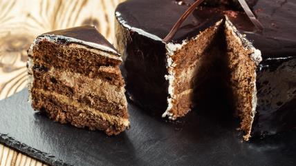 Minjon torta ukrašena čokoladnom glazurom na crnom poslužavniku na stolu