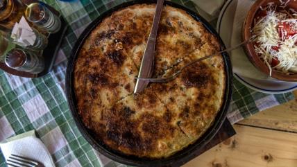 Pita poparenica ispečena u ručanom sudu i poslužena na stolu