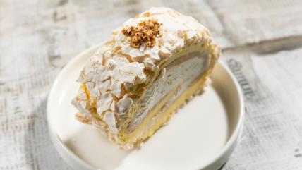 Puslica rolat sa lešnicima i čokoladom na belom tanjiru na stolu