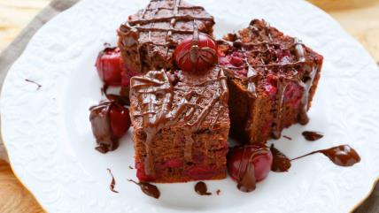 Pijani čokoladni kolač sa višnjama na belom tanjiru