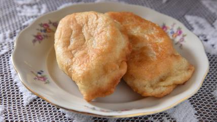 Punjeni langoš na tanjiru na stolu sa štrikanim stolnjakom