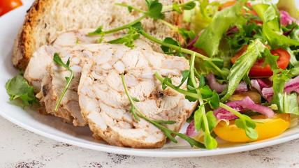 Pileća pečenica na tanjiru sa hlebom i salatom