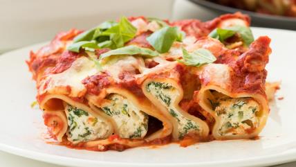 Kaneloni sa spanaćem i sitnim sirom na belom tanjiru