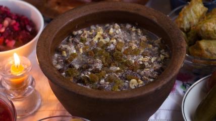 Sladak pasulj za zadušnice u zemljanoj posudi na stolu pored sveće