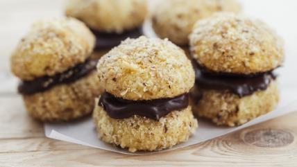 Krešenti, sitni kolači sa orasima i čokoladom na pek papiru na stolu