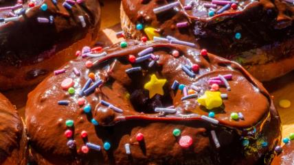 Američke krofnice prelivene čokoladnom glazurom i posute šarenim mrvicama