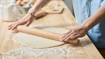 Žena razvlači testo uz pomoć okaglije