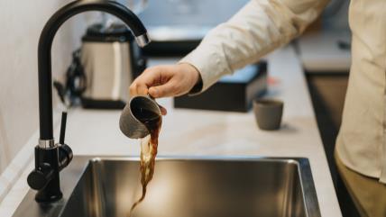 Čovek prosipa kafu u sudoperu