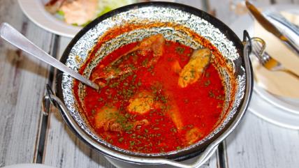 Riblja čorba u kotliću na stolu