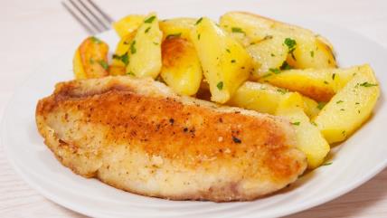 Hrskavi oslić iz rerne sa marinadom od peršuna i belog luka i krompir salatom na belom tanjiru