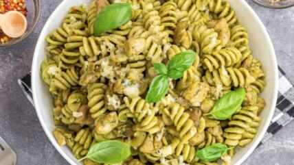 Pesto pasta sa piletinom u beloj činiji na stolu
