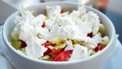 Šopska salata u beloj činiji na stolu