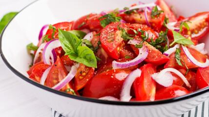 Paradajz salata u beloj činiji sa lukom