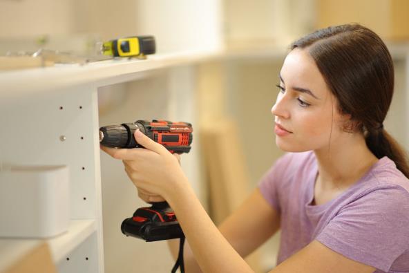 Žena šrafi ormar i renovira kuhinju