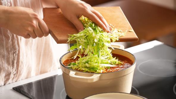 Žena ubacuje iseckani kupus u šerpu