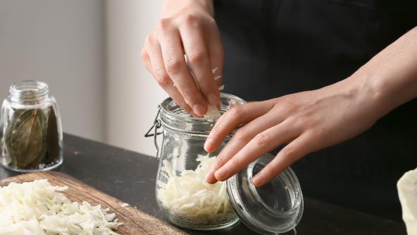 Žena stavlja kupus u teglu za ribanac