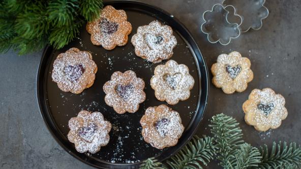 Linceri sa džemom posuti prah šećerom na tanjiru na stolu