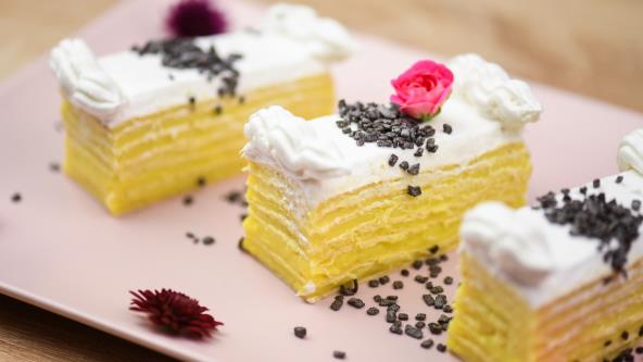 Rozen kocke sa belom čokoladom na tanjiru ukrašene šlagom, čoko mrvicama i cvećem