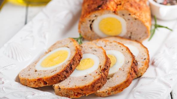 Mesna veknica punjena jajima na belom tanjiru