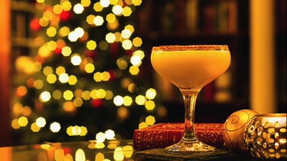 Mimoza koktel pored ukrasa na stolu, jelka svetli u pozadini