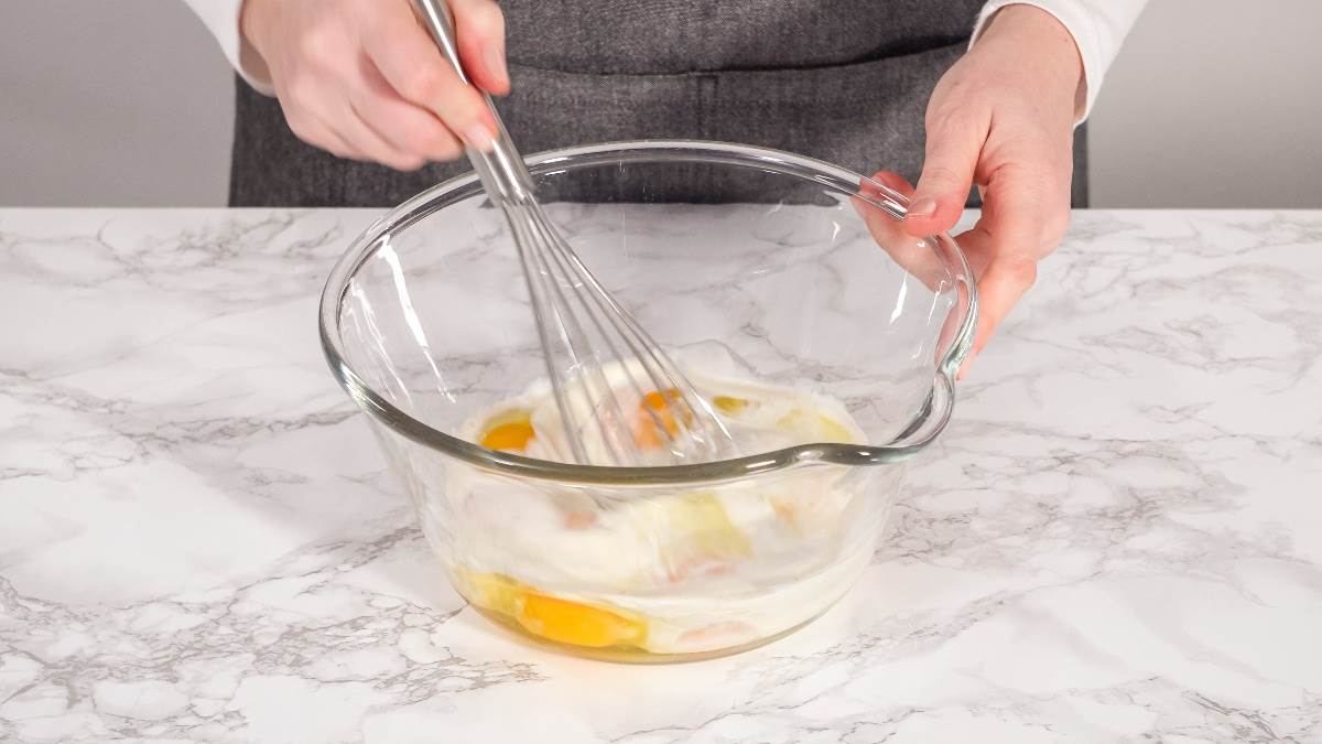 Mešanje mokrih sastojaka za banana hleb u staklenoj činiji